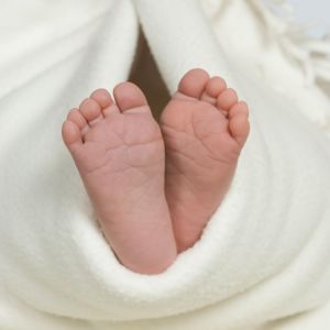 Pair of baby's feet poking out from blanket, close-up