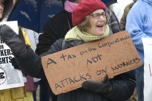Protestor with a sign reading 'A tax on the Corporations NOT Attacks on Workers' at a rally in solidarity with the labor protests (happening in Wisconsin) in Springfield, Massachusetts, USA on Monday, 4 April 2011. A coalition of labor unions and cit