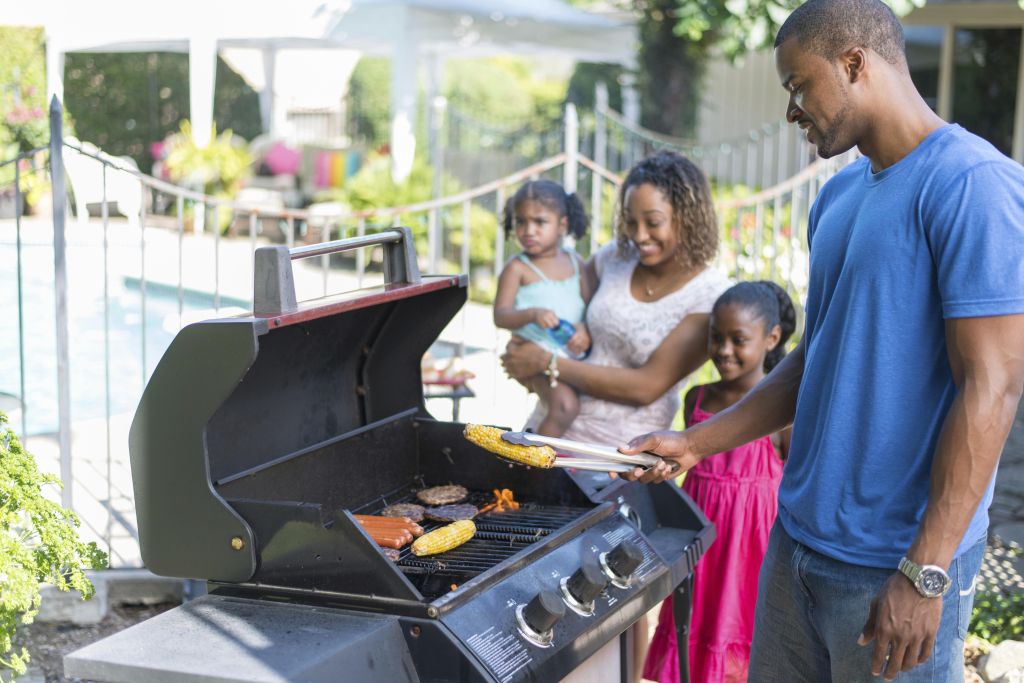 A family having a BBQ on the deck.