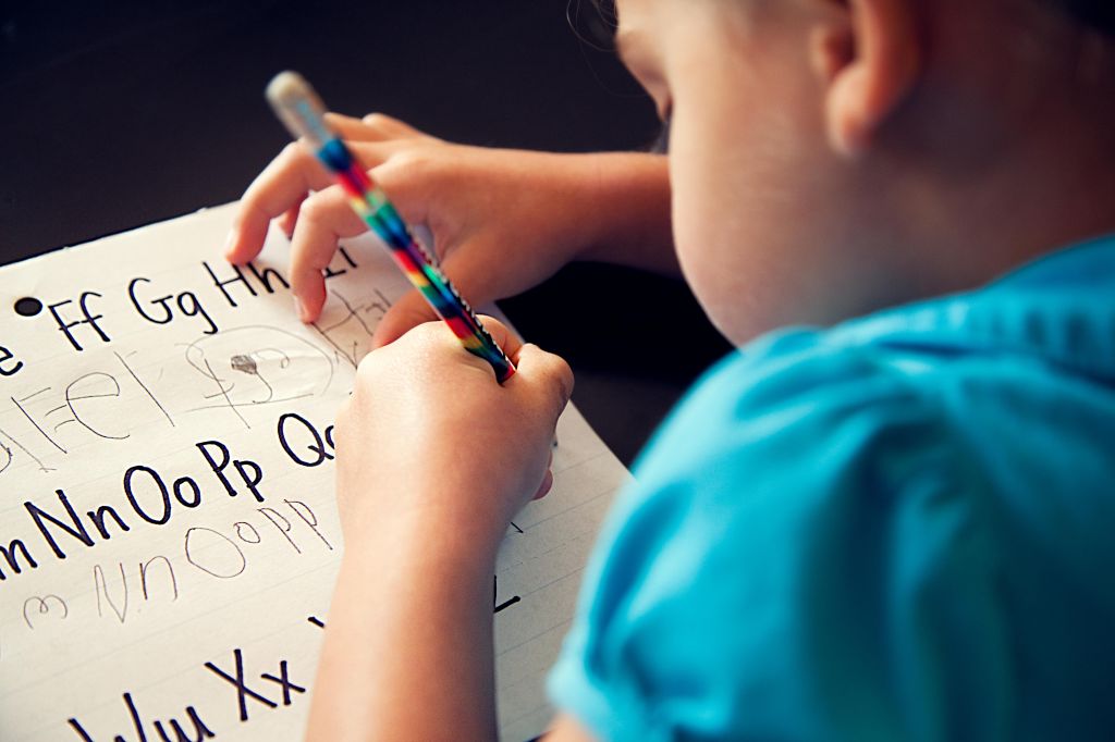 Preschool girl copying her letters