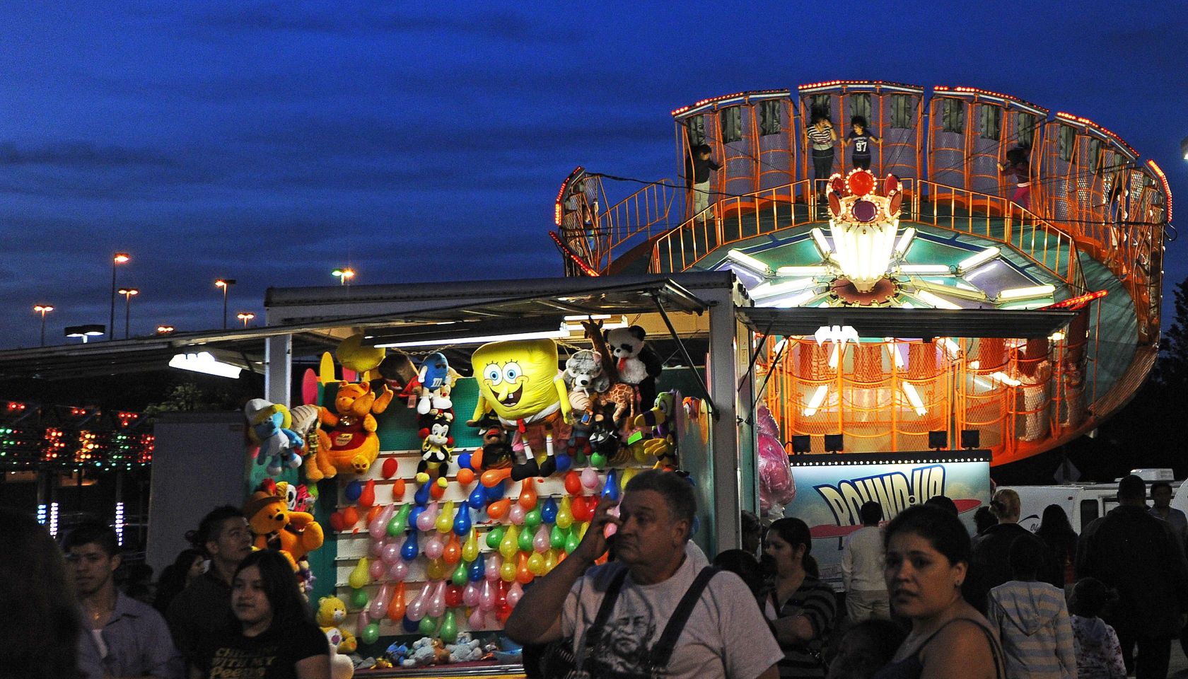 People wonder around various rides and s