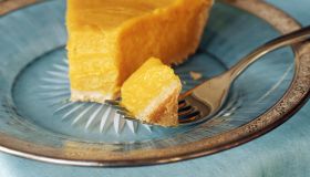 Slice of pumpkin pie with piece on fork, close-up