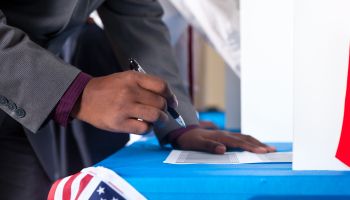 Man's hands while voting in election vote booth