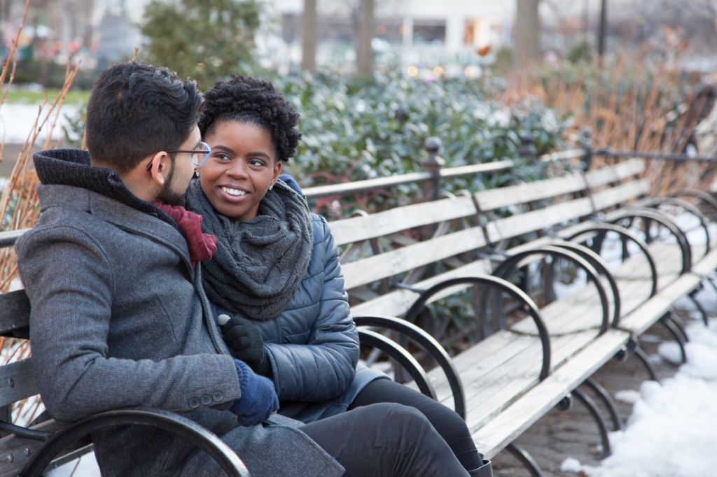 Loving Multi-Ethnic Couple sitting on a park bench