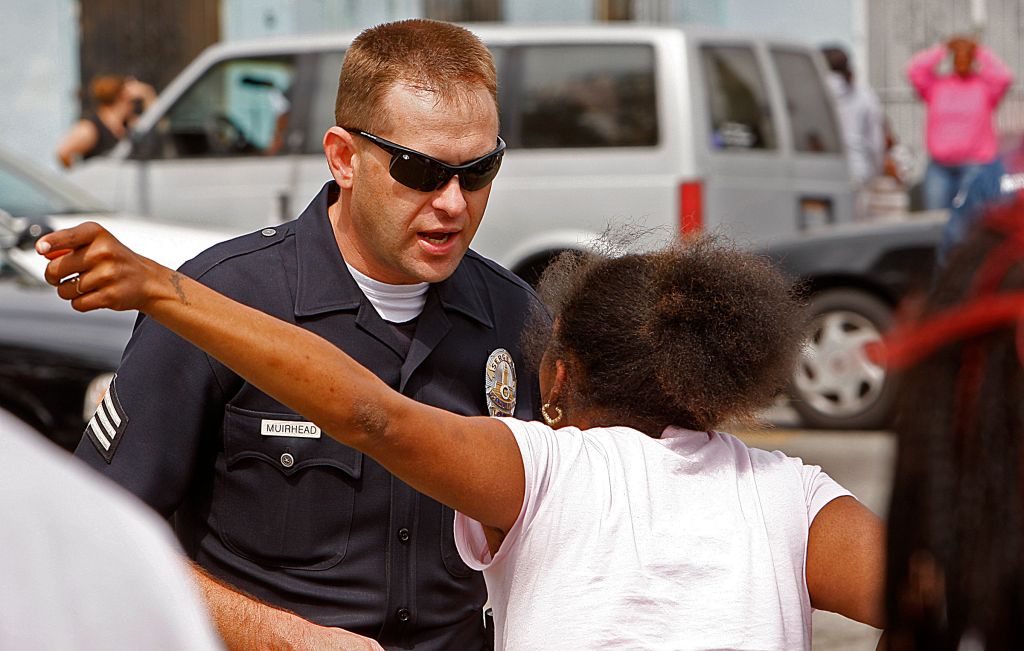 An LAPD officer talks to an irate parent waiting Friday, May 9, 2008, at Locke High School in South