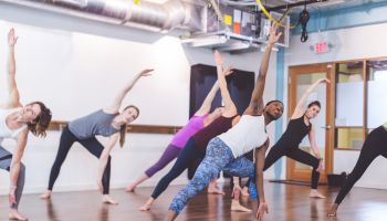 Group of Women Doing Barre + TRX Workout