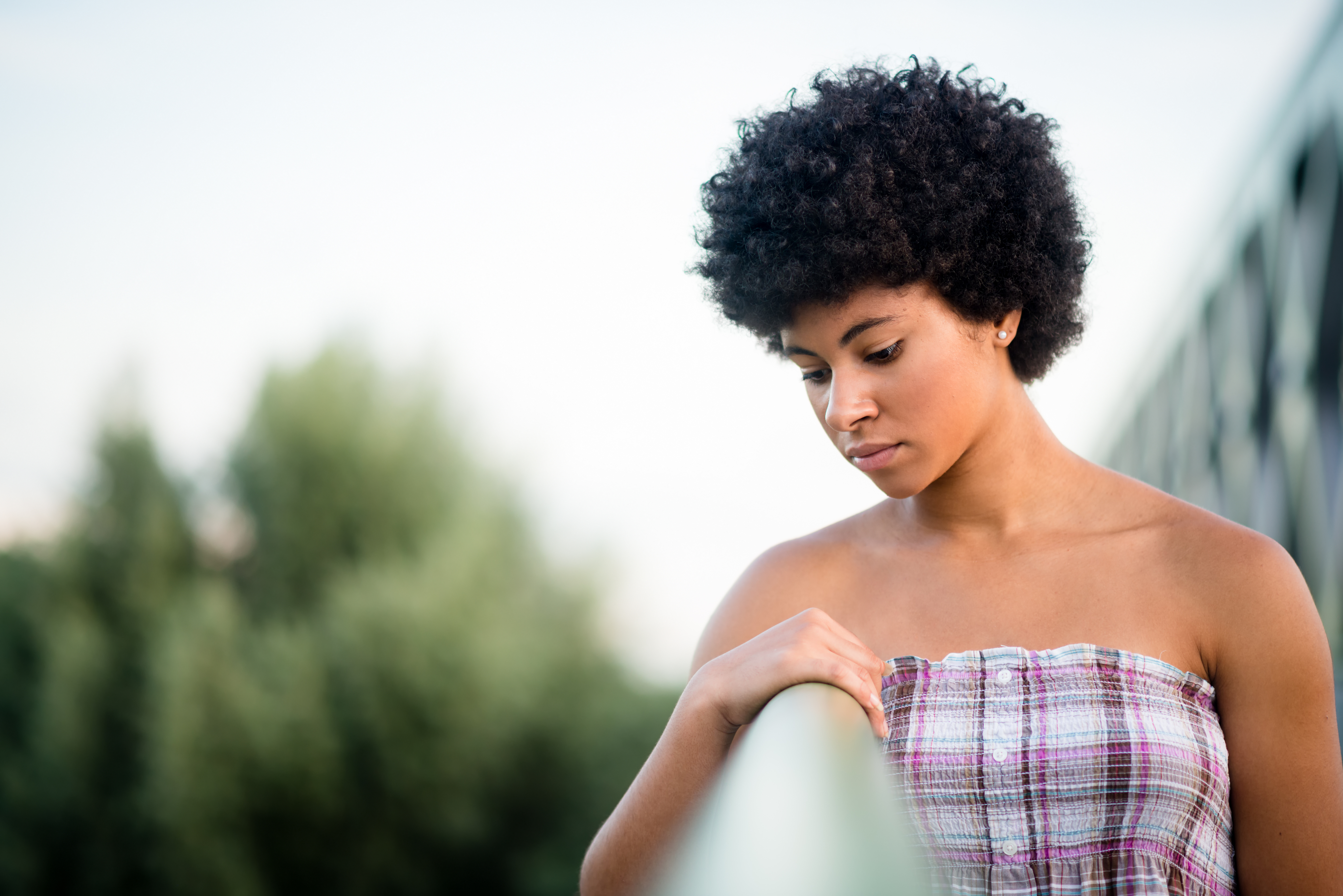 Sad teen girl standing on the bridge. Alone and thoughtful.