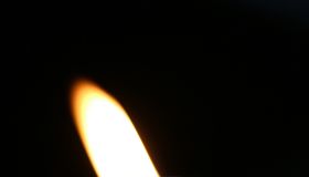 Close-Up Of Burning Candle In Darkroom