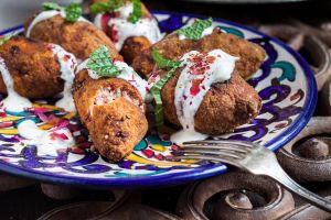 Kibbeh, oriental meat croquettes with yoghurt sauce on plate