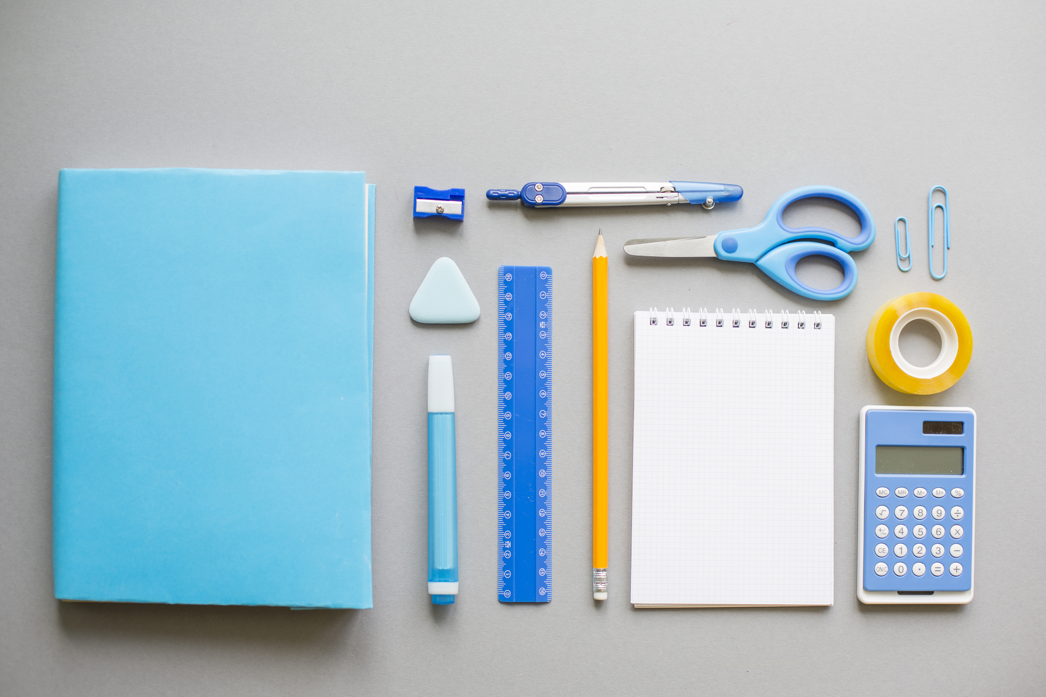 Blue school supplies on grey background