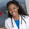 African American female doctor tossing apple