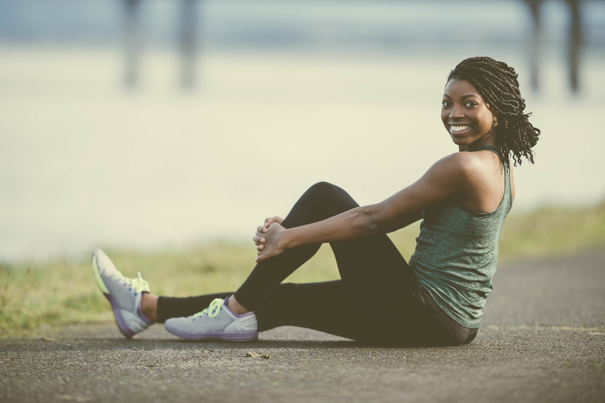 African American woman doing yoga outside by river