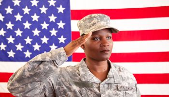 African descent female in military uniform saluting American flag