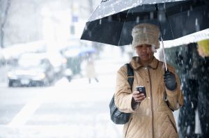 Black woman text messaging in the rain