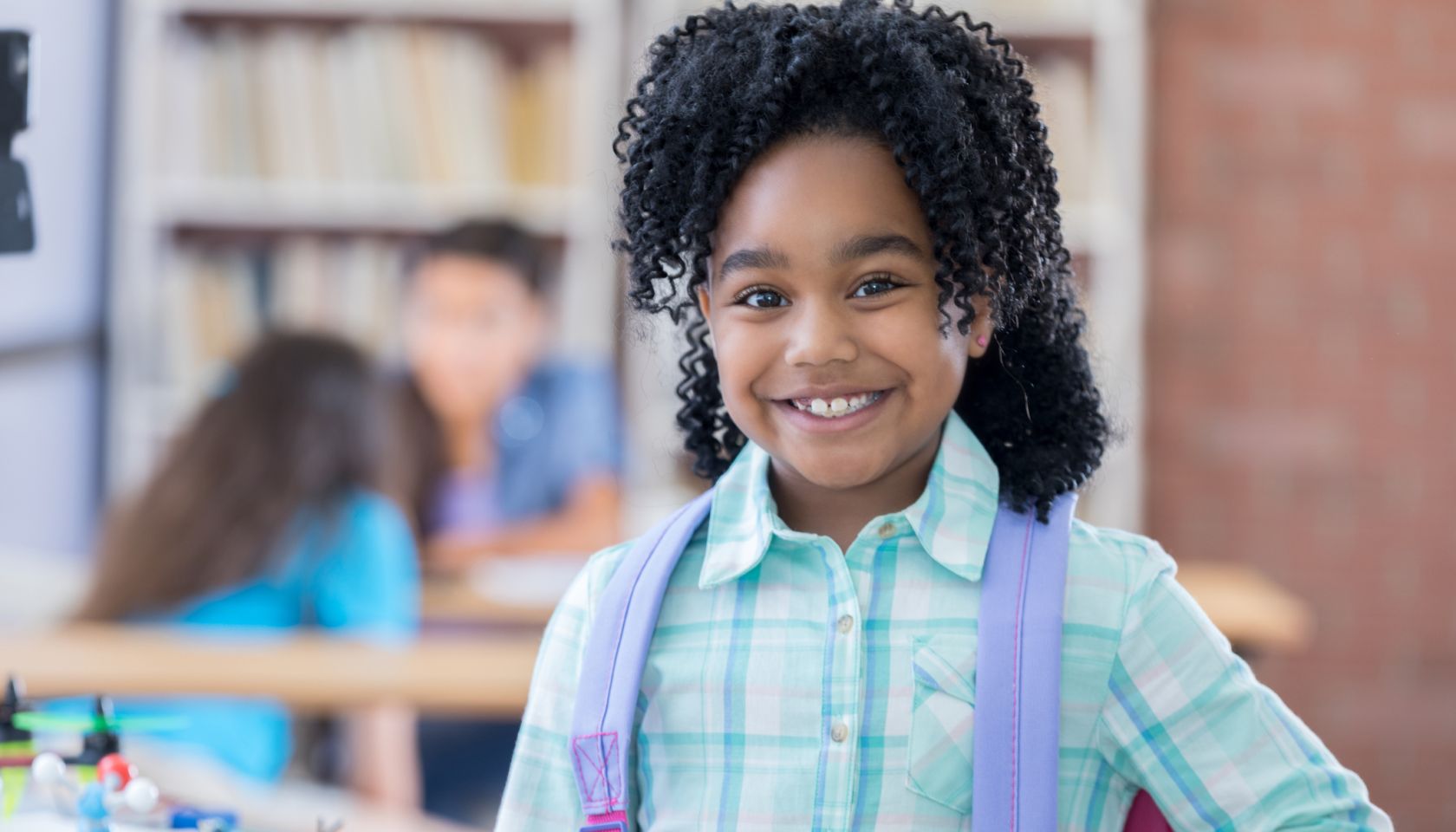 Elementary age little girl smiles for camera at school
