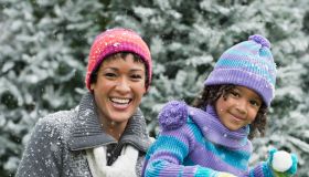 Black mother and daughter having a snowball fight