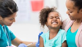 Young girl grimaces while getting a shot
