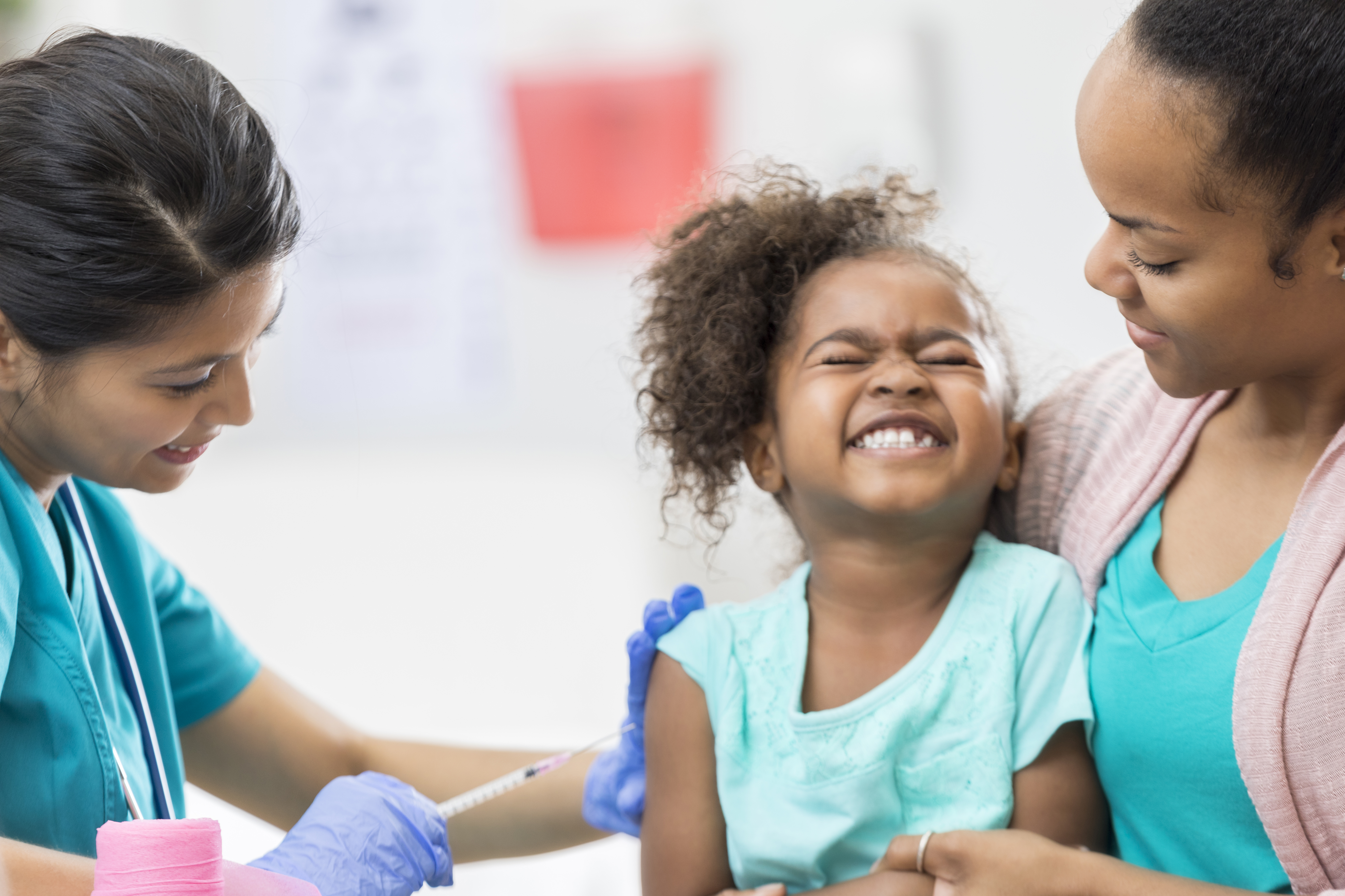 Young girl grimaces while getting a shot