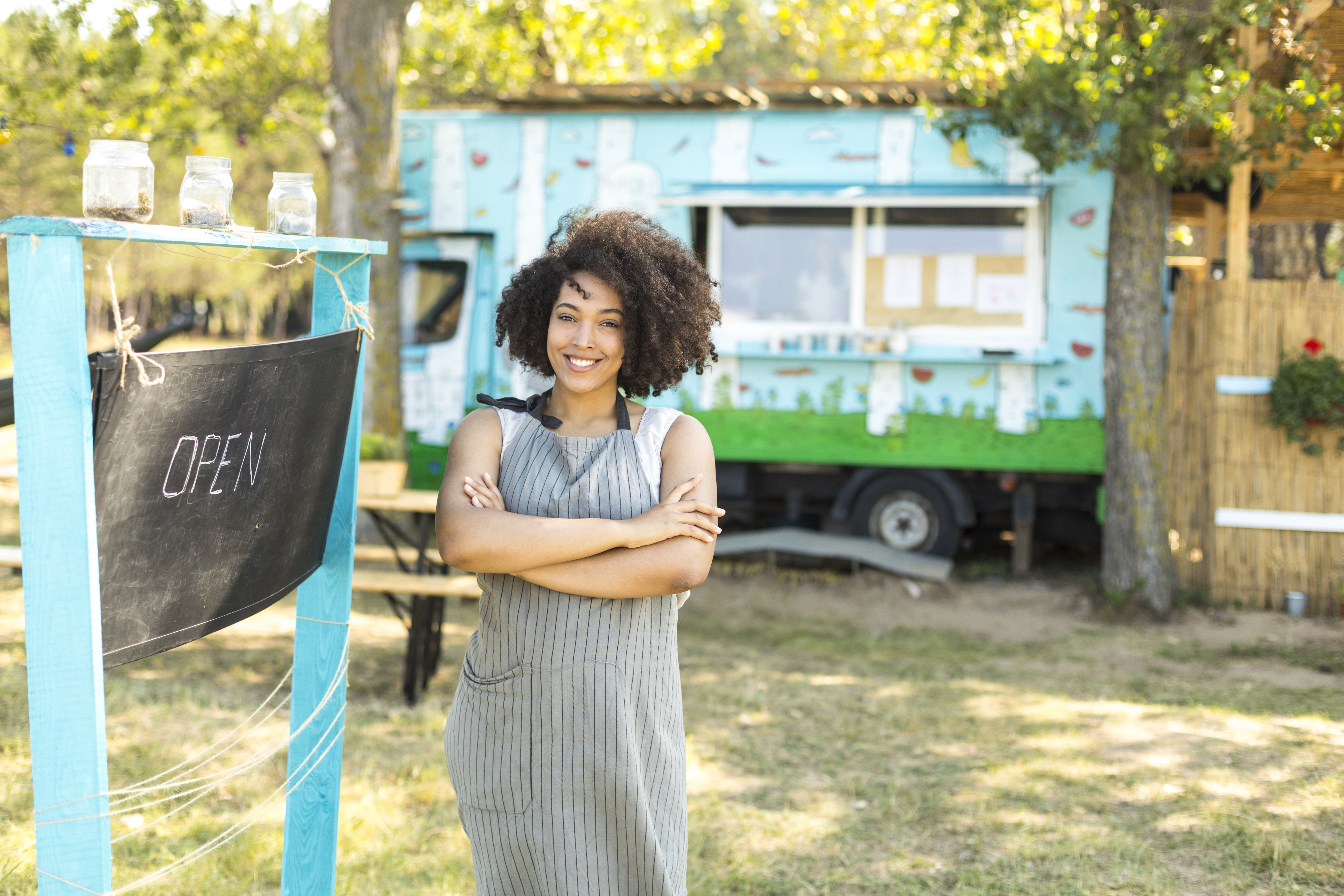 Food van owner posing next to signboard
