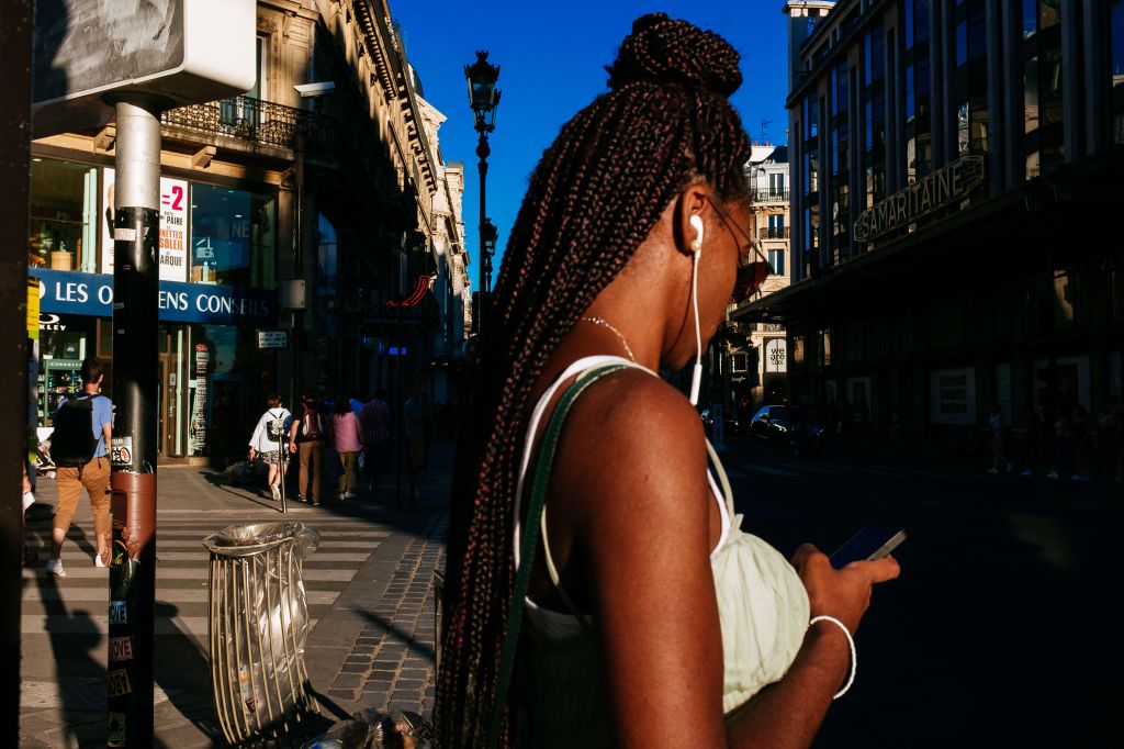 Young afro french woman wearing african braids standing on...