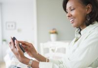 Black woman text messaging on cell phone