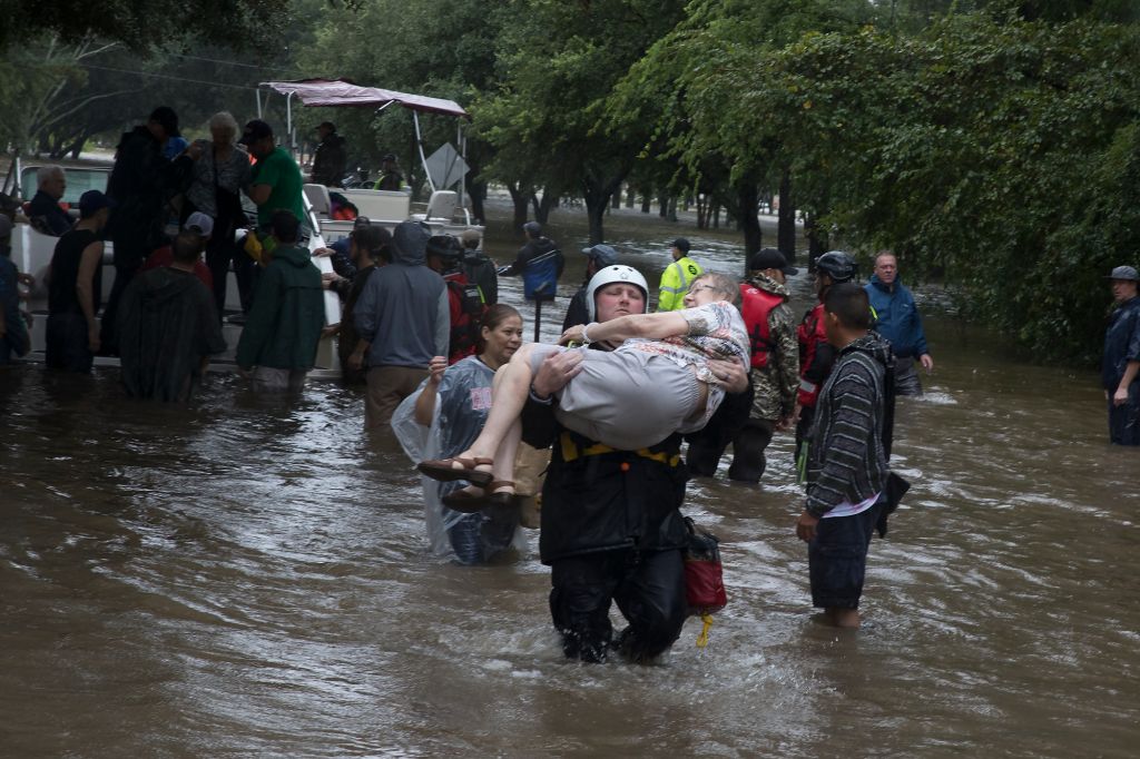Police and volunteers rescue residents flooded by the San Jacinto river in Kingwood, Texas
