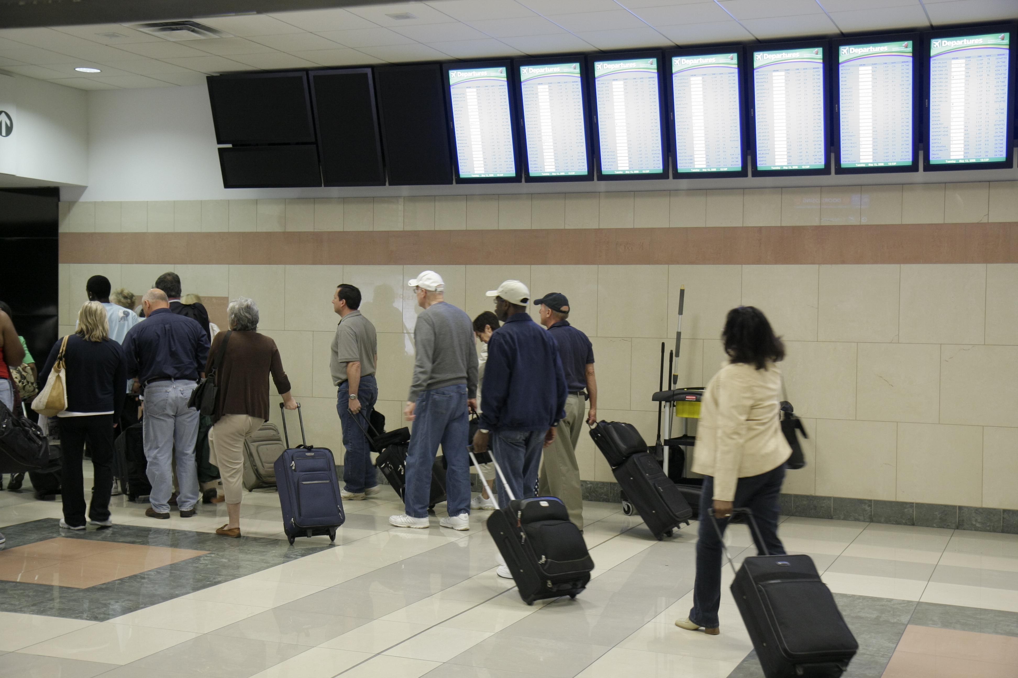 Passengers with rolling luggage at Hartsfield-Jackson Atlanta International Airport.
