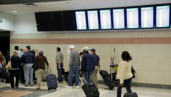 Passengers with rolling luggage at Hartsfield-Jackson Atlanta International Airport.