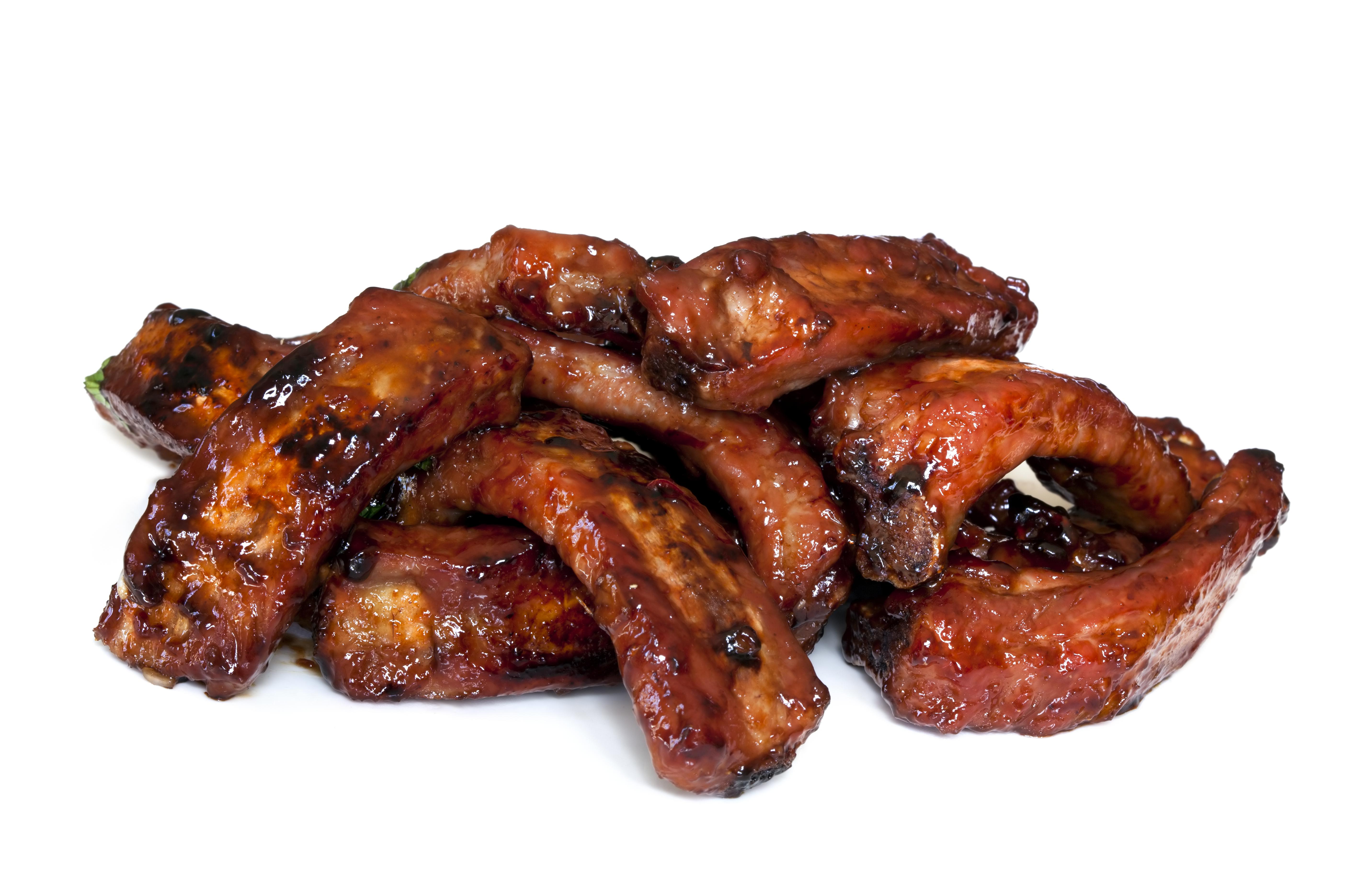Pile of barbecued baby back pork ribs, isolated on white. Sticky and delicious!