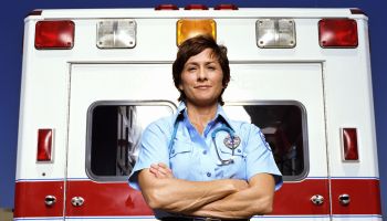 Emergency medical technicians standing outside ambulance, portrait