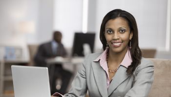 Mixed race businesswoman using laptop at desk