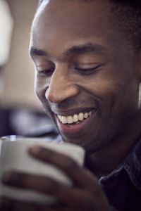 close-up portrait of a man with a coffee cup