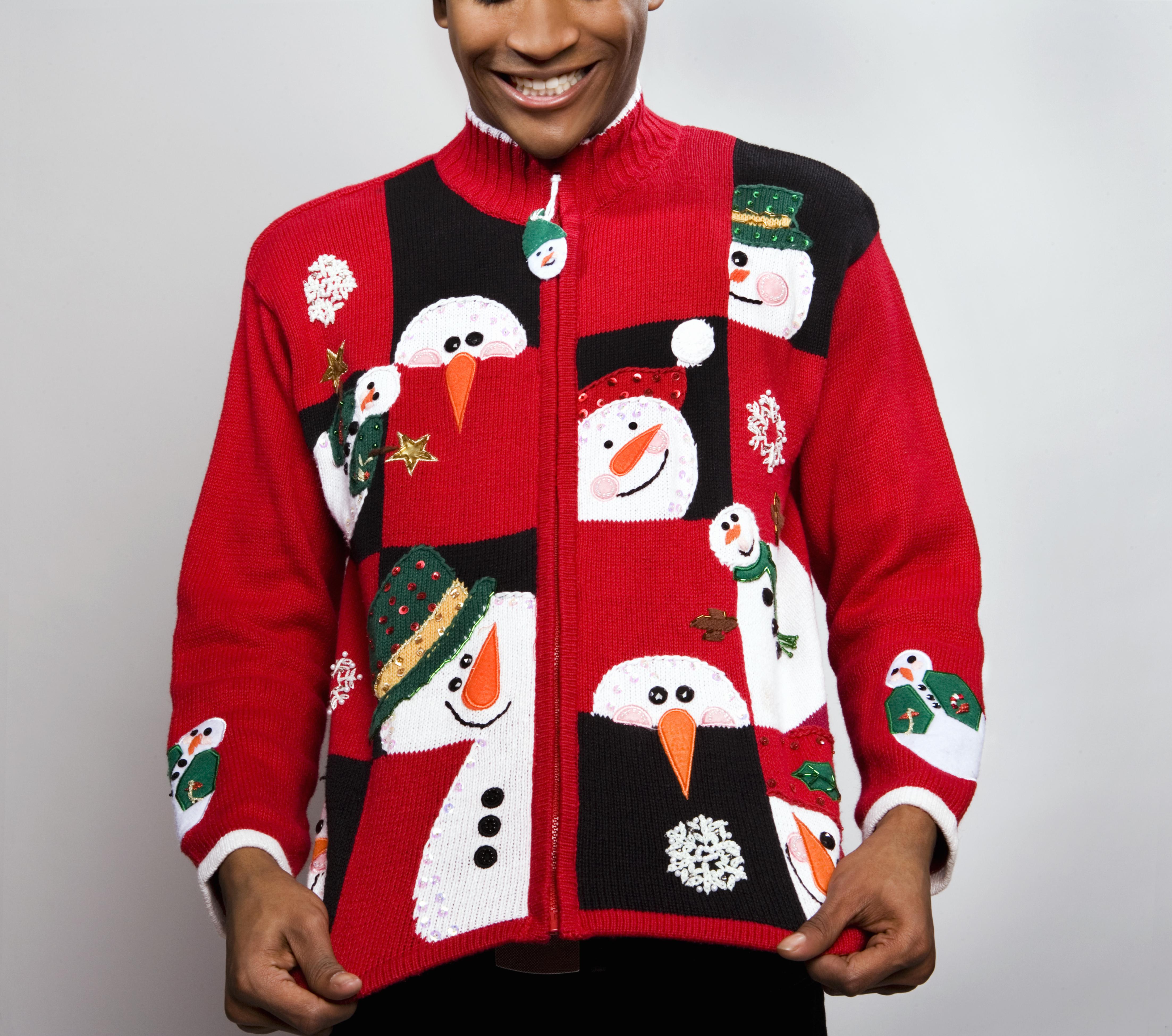 Man wearing Christmas sweater, smiling, studio shot