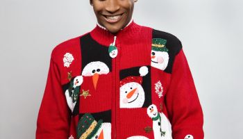 Man wearing Christmas sweater, smiling, studio shot