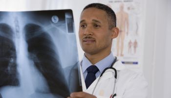African doctor looking at x-ray