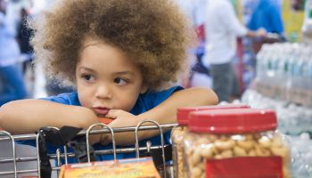 Mixed race boy sitting in shopping cart