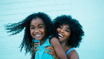 Portrait of Black mother and daughter laughing