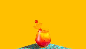 Red and Yellow cocktail shot over a graphic colorful background