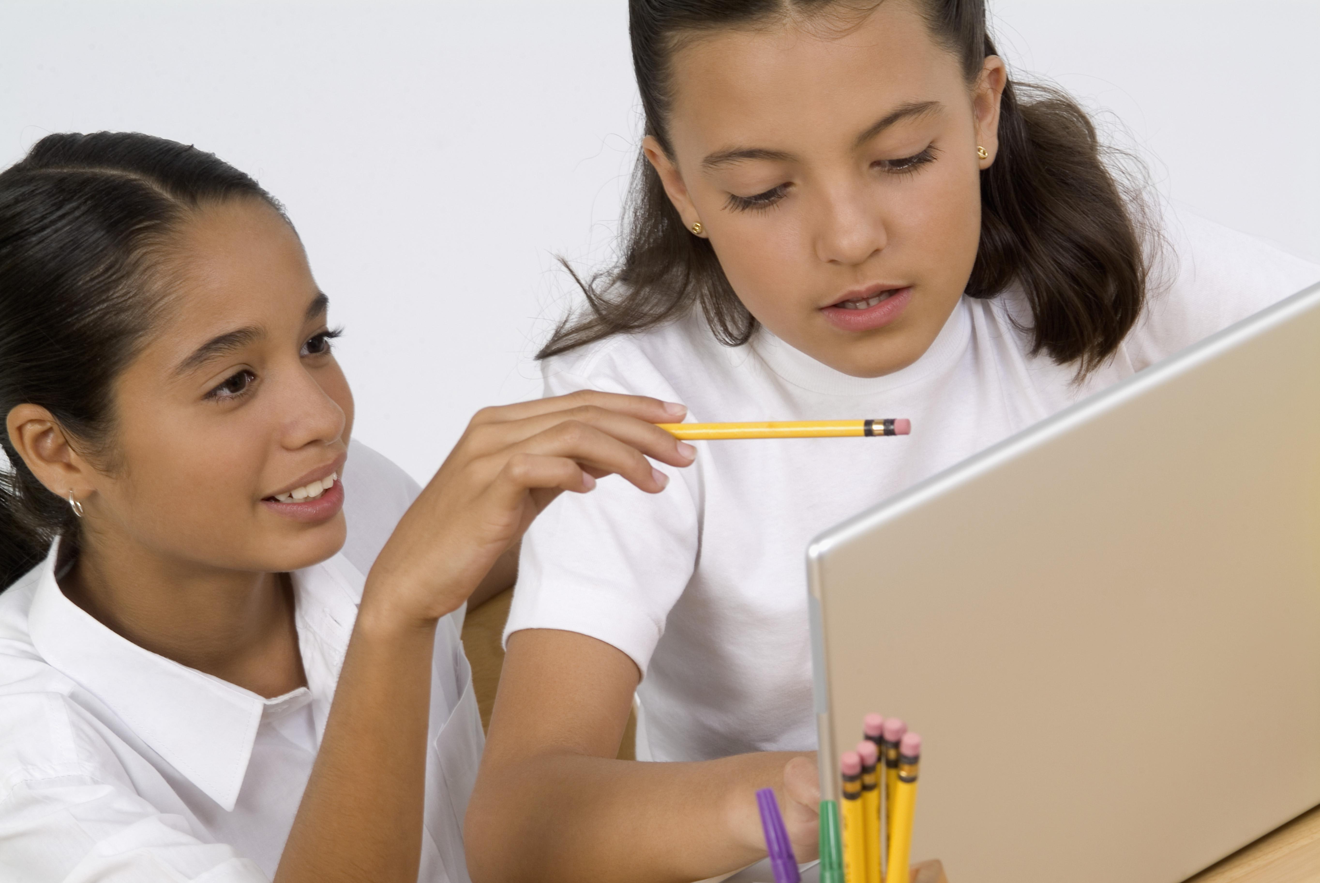 Two girls studying with laptop computer, close-up
