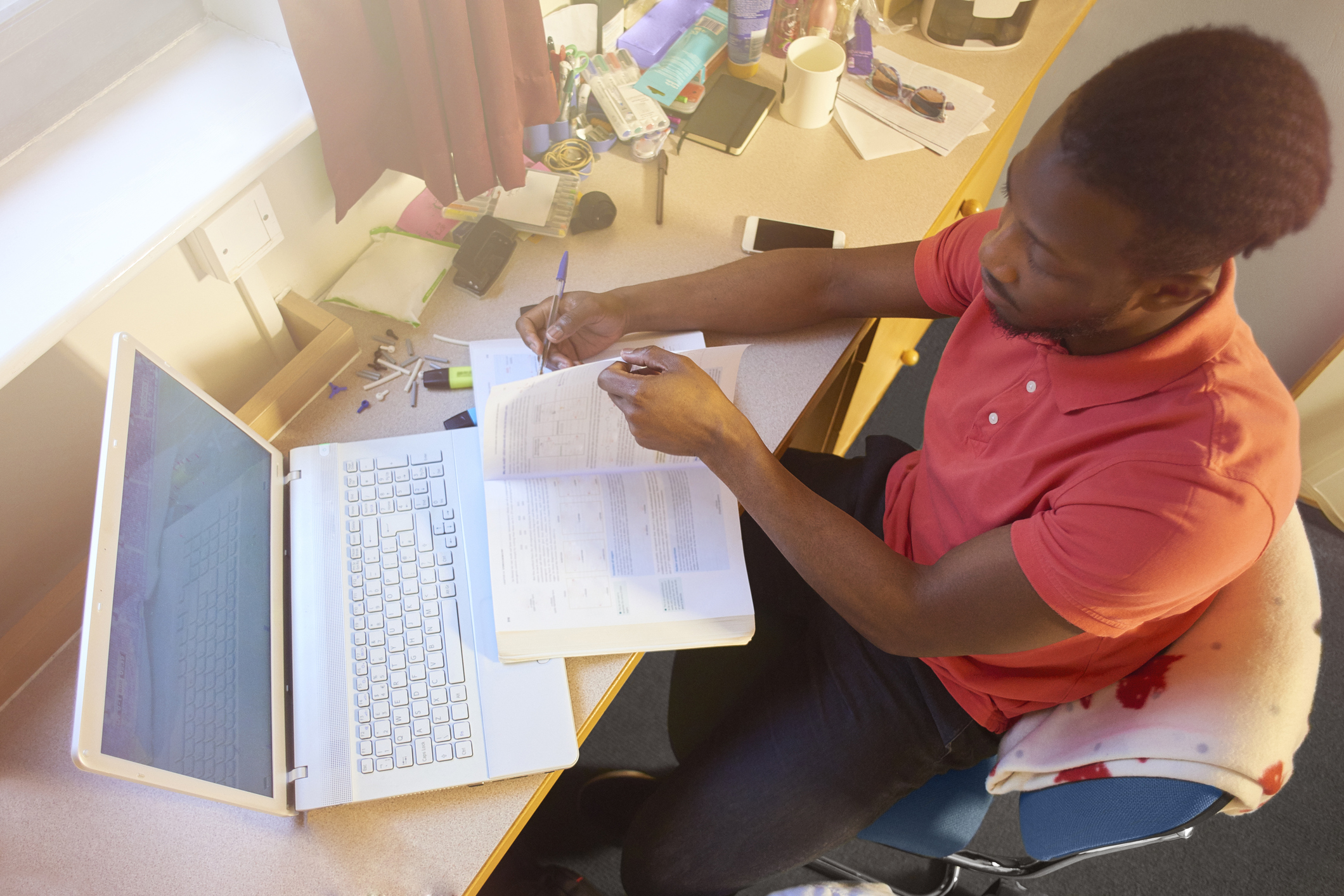 Male university student studying in his room at uni