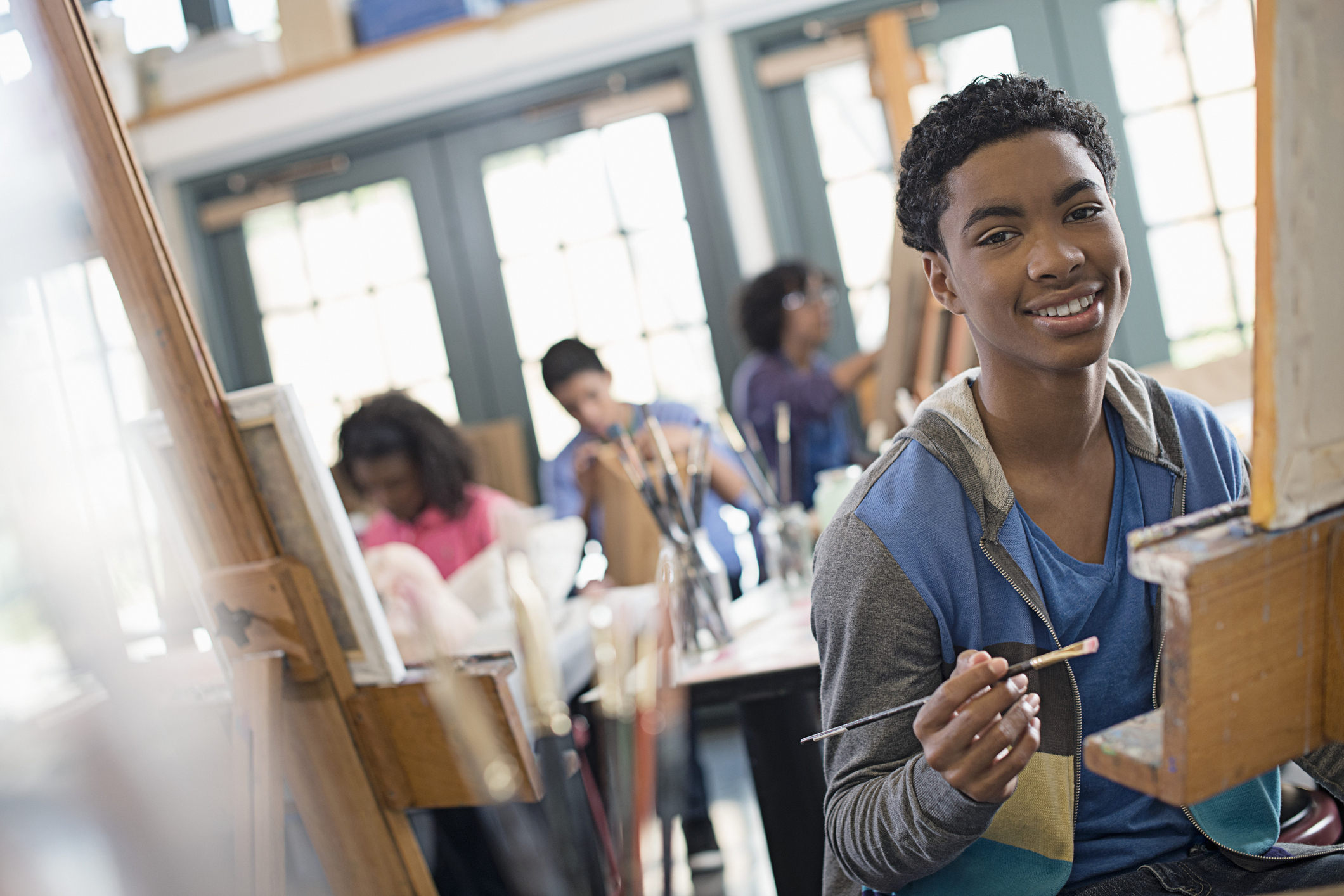 Young artist painting on easel