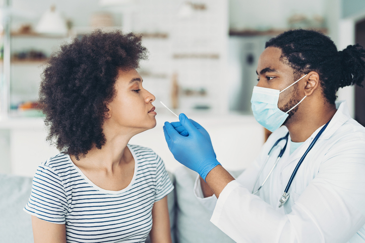 Doctor taking a covid-19 test sample from a patient's nose