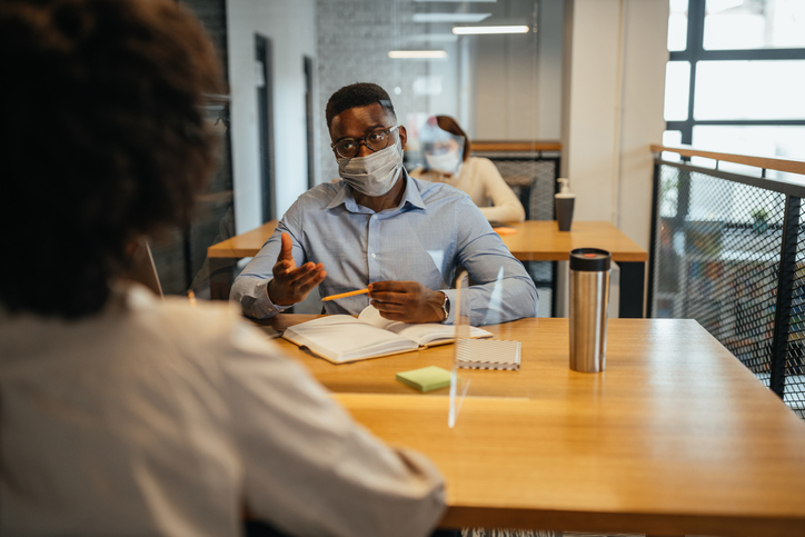 Businesspeople wearing masks in the office during COVID-19 pandemic