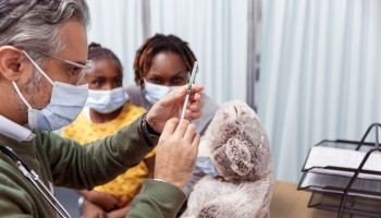 Pediatrician preparing to give child a COVID-19 vaccination