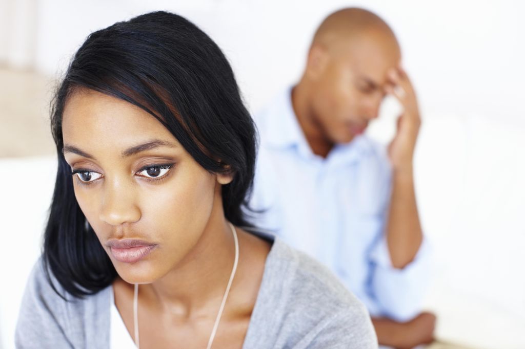 Worried young woman and man in living room
