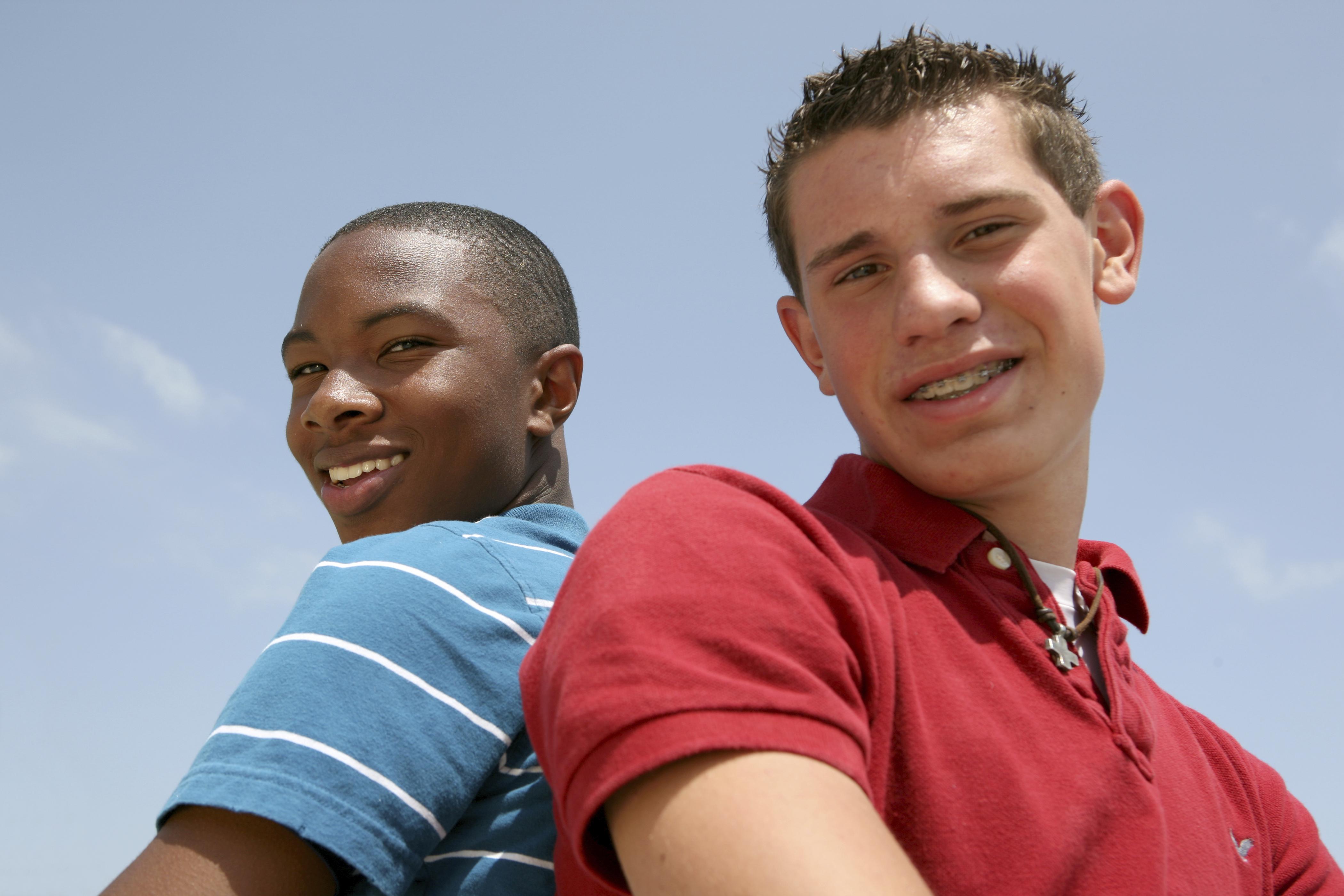 Two Teenagers Standing With Their backs To One Another