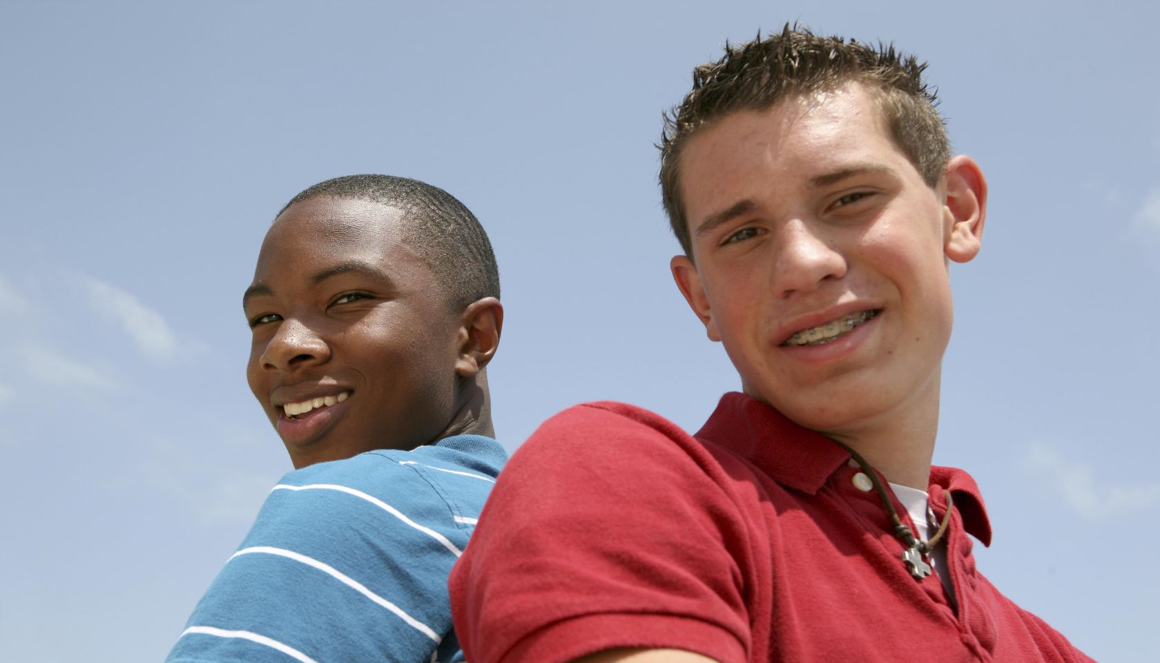 Two Teenagers Standing With Their backs To One Another