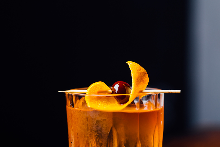 Alcoholic Old Fashioned Cocktail classic Bourbon Whiskey, sugar cube and aromatic bitters garnish with orange peel and a cherry
