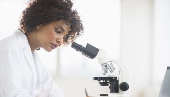 USA, New Jersey, Jersey City, Woman using microscope in laboratory