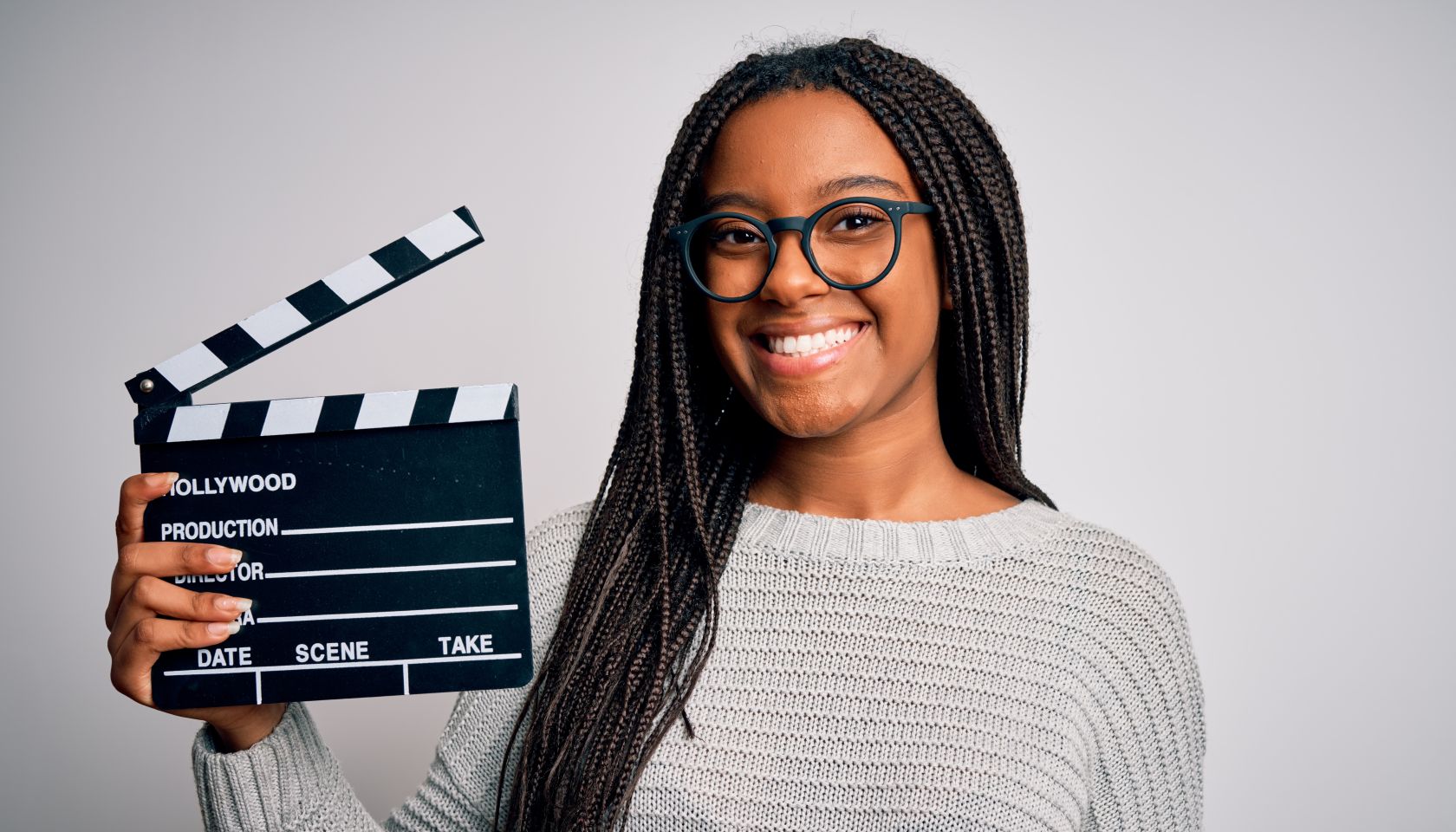 Young african american director girl filming a movie using clapboard